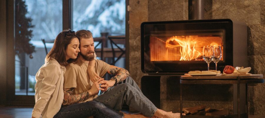 Man and Woman Sitting on Floor Near Fireplace