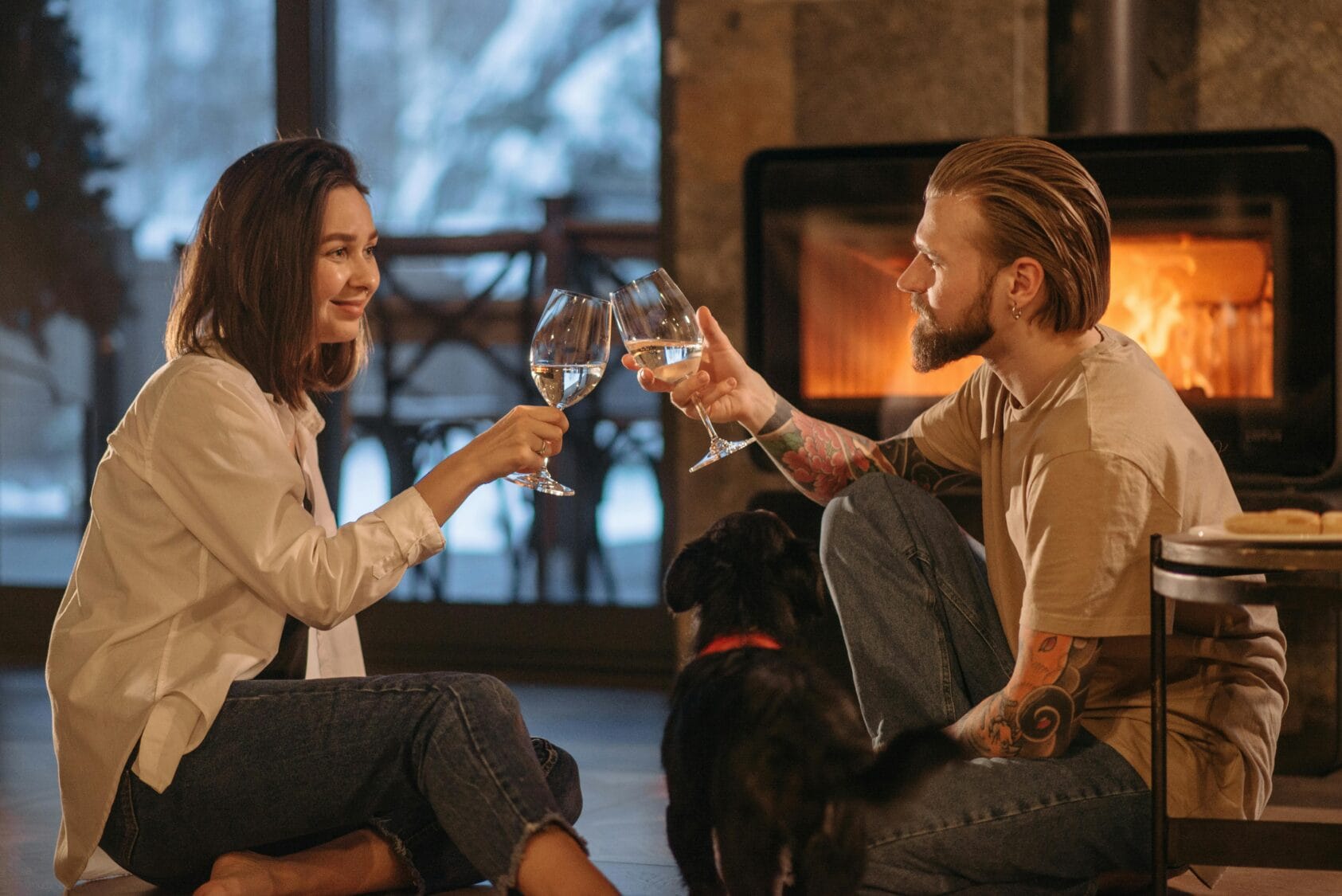 Man and Woman Sitting on Floor Near Fireplace