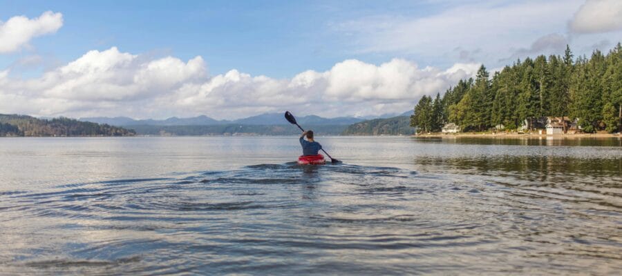 Person on Kayak Under Blue and White Sky